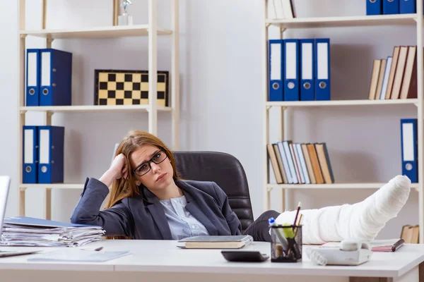 Angestellte mit gebrochenem Bein im Büro — Stockfoto