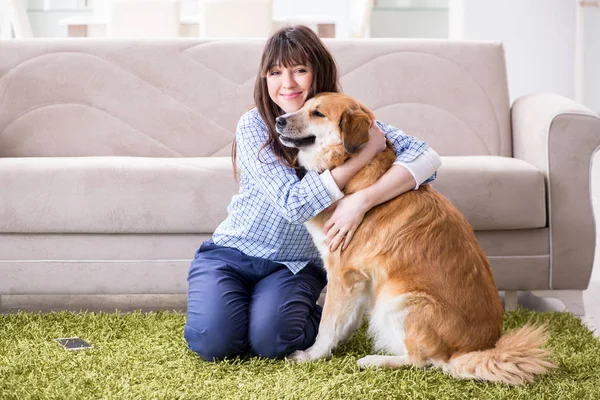 Mulher feliz cão proprietário em casa com golden retriever — Fotografia de Stock