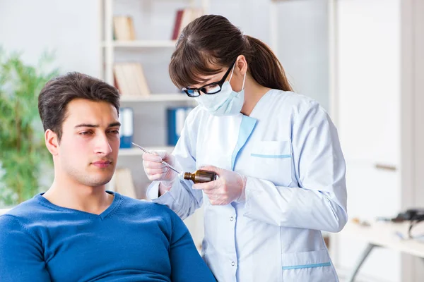 Doctor checking patients ear during medical examination