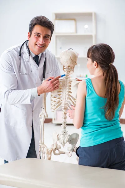 Lékař ukazující typ poranění na kostře pacientovi — Stock fotografie