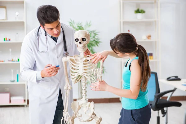 Médico mostrando tipo de lesión en el esqueleto al paciente — Foto de Stock