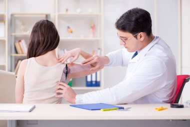 Doktor hastaların eklem esnekliğini gonimetreyle kontrol ediyor.