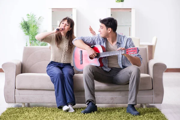 Jonge familie die thuis muziek zingt en speelt — Stockfoto