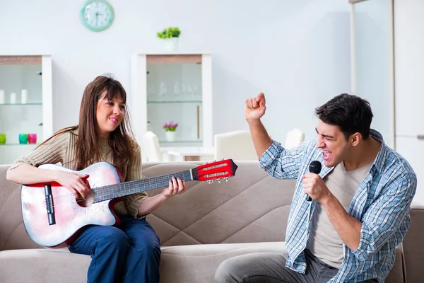 Jonge familie die thuis muziek zingt en speelt — Stockfoto