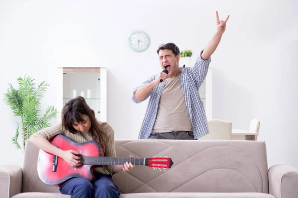 Jonge familie die thuis muziek zingt en speelt — Stockfoto