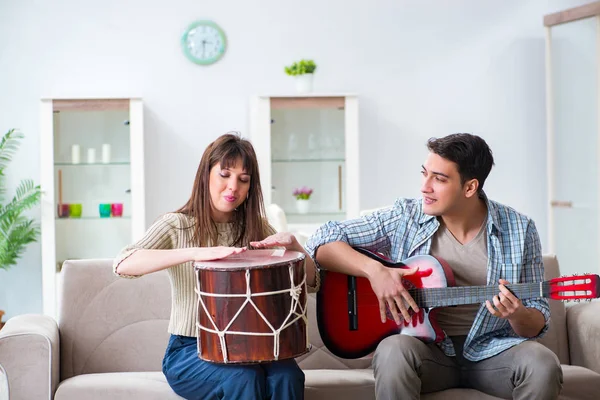 Jonge familie die thuis muziek zingt en speelt — Stockfoto