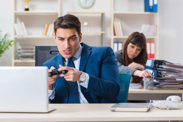 Man speelt spelletjes terwijl collega bezig is — Stockfoto