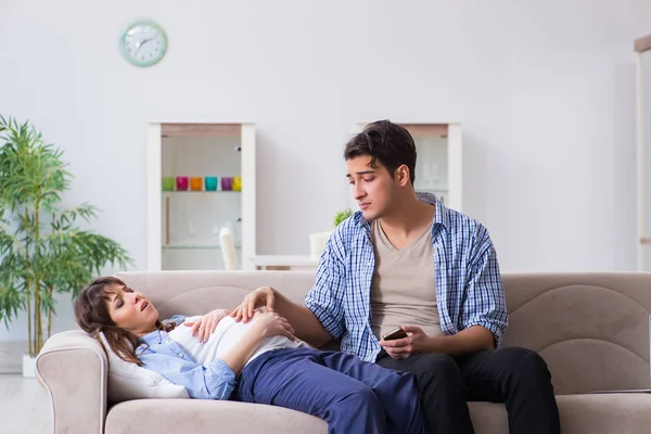 Pregnant woman with husband at home — Stock Photo, Image