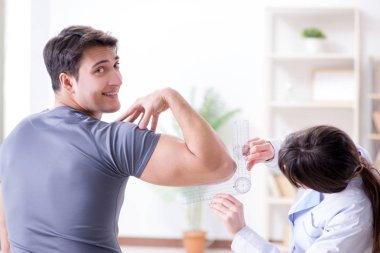 Doktor hastaların eklem esnekliğini gonimetreyle kontrol ediyor.