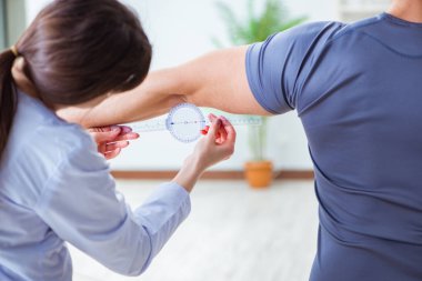 Doktor hastaların eklem esnekliğini gonimetreyle kontrol ediyor.