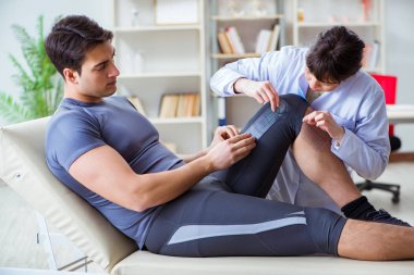 Doktor hastaların eklem esnekliğini gonimetreyle kontrol ediyor.