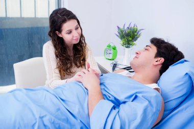 Karısı hasta kocasını hastanede ziyaret ediyor.