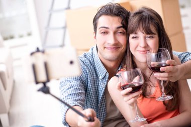 Bir çift selfie çekip şarap içiyor.