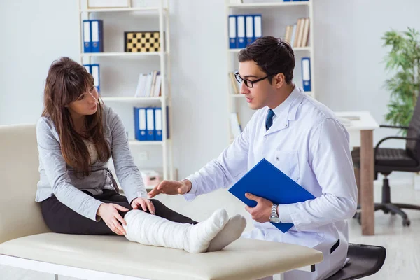 Doctor examining patient with broken leg — Stock Photo, Image