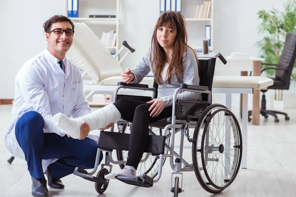 휠체어를 타고 여성 환자를 진찰하고 있는 남성 의사 — 스톡 사진
