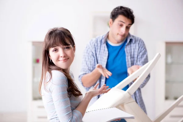 Esposa ayudando a marido a reparar silla rota en casa —  Fotos de Stock