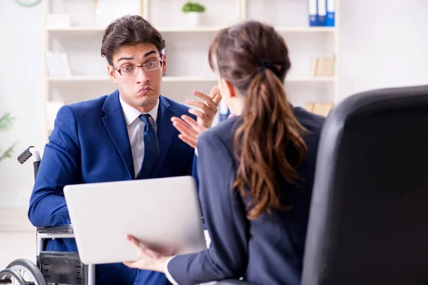 Бізнесмен з обмеженими можливостями обговорює з колегою-жінкою — стокове фото