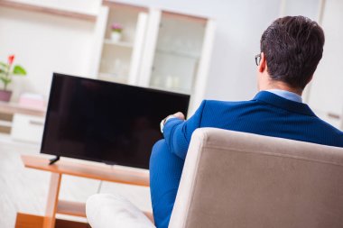 İş adamı ofiste televizyon izliyor.