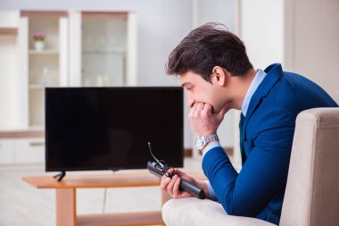 İş adamı ofiste televizyon izliyor.