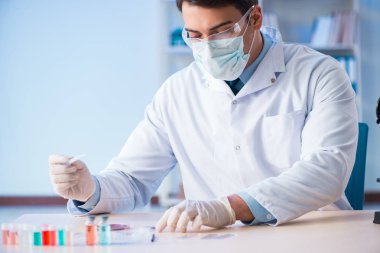 Laboratuvar asistanı hastanede kan örneklerini test ediyor.