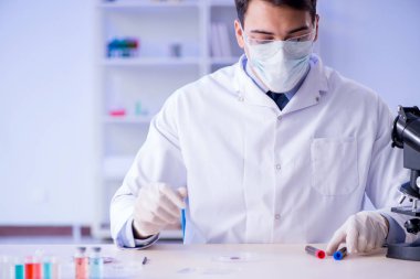 Laboratuvar asistanı hastanede kan örneklerini test ediyor.