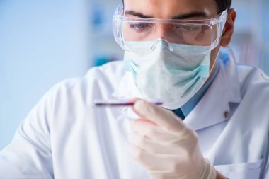 Laboratuvar asistanı hastanede kan örneklerini test ediyor.