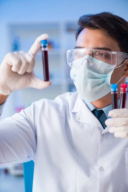 Laboratuvar asistanı hastanede kan örneklerini test ediyor.