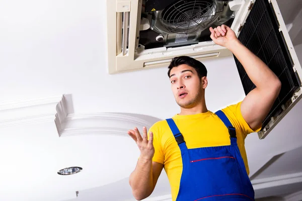 Repairman repairing ceiling air conditioning unit — Stock Photo, Image
