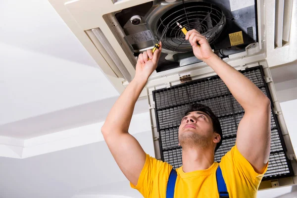 Repairman repairing ceiling air conditioning unit — Stock Photo, Image