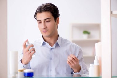 Adam banyoda çalışmak için giyiniyor.