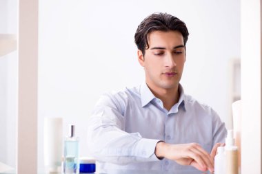 Adam banyoda çalışmak için giyiniyor.