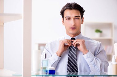 Adam banyoda çalışmak için giyiniyor.