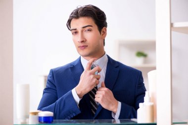 Adam banyoda çalışmak için giyiniyor.