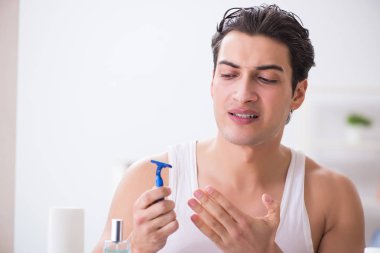 Genç yakışıklı adam sabah erkenden tıraş oluyor.