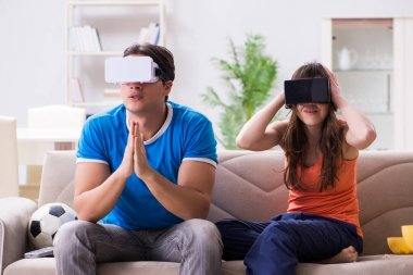 Adam sanal gerçeklik VR gözlükleriyle futbol izliyor.