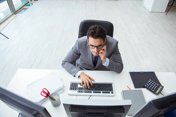 Genç işadamı masasında çalışıyor.