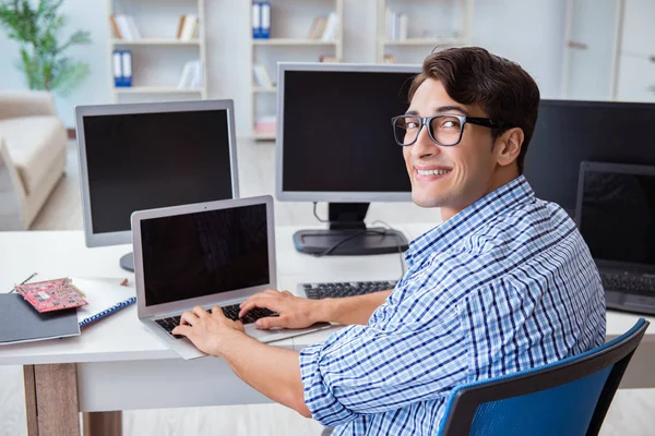 Birçok ekranın önünde oturan bir iş adamı