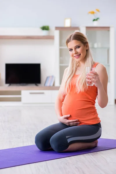 妊娠中の女性が家で運動をする — ストック写真
