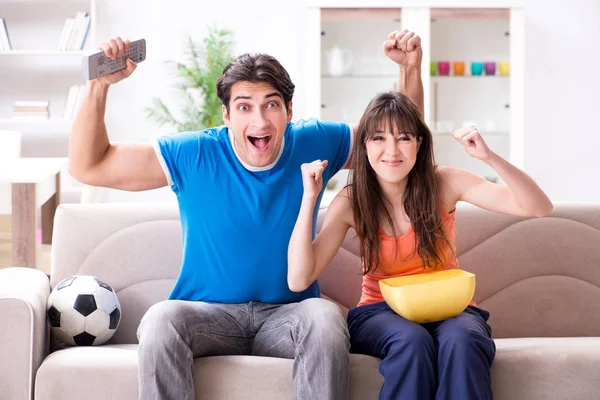 Jongeman kijkt voetbal met zijn vrouw thuis — Stockfoto
