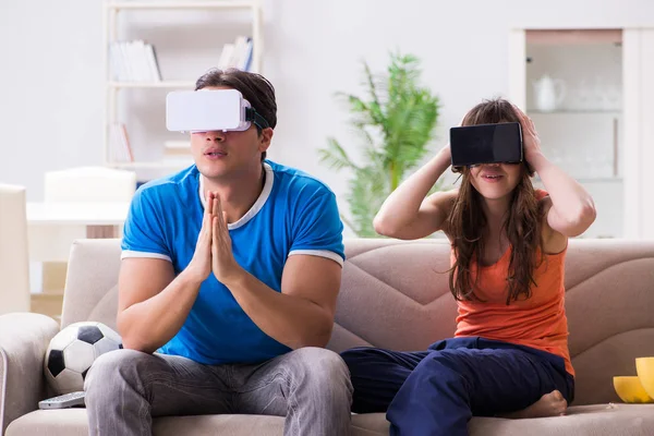 Adam sanal gerçeklik VR gözlükleriyle futbol izliyor.