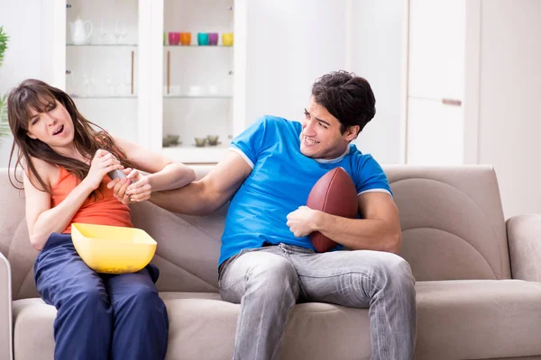 Homem assistindo futebol americano com sua esposa — Fotografia de Stock