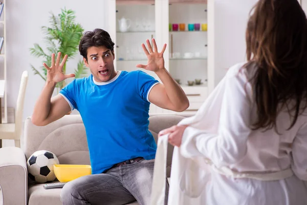 Junge Frau versucht Ehemann vom Fußballgucken zu verführen — Stockfoto