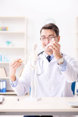Doktor iskelette insan vücudunu açıklıyor.