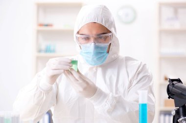 Laboratuvarda kimyasallar üzerinde çalışan genç bir kimyager.