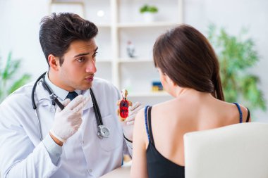 Doktor muayene sırasında hastaların kulaklarını kontrol ediyor.