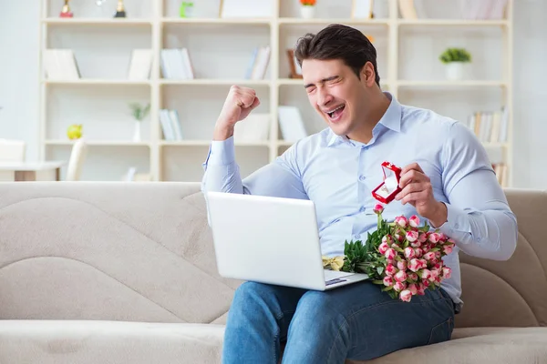 Hombre joven haciendo propuesta de matrimonio a través de Internet portátil —  Fotos de Stock