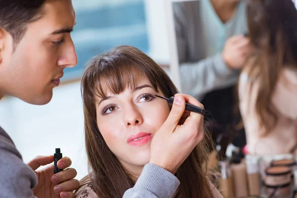 Uomo che fa il make-up per la donna carina nel salone di bellezza — Foto Stock