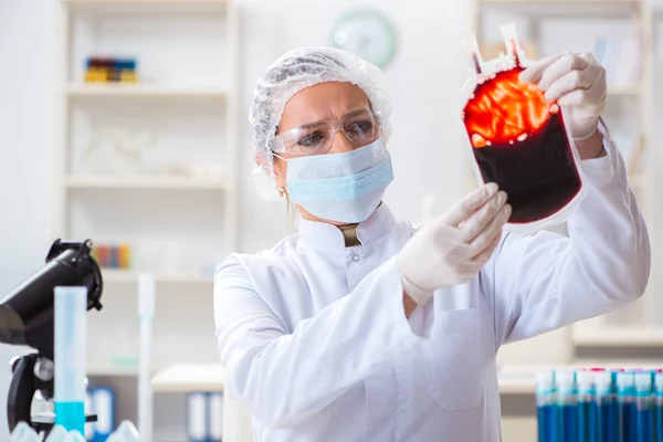Mujer doctora revisando muestras de sangre en laboratorio —  Fotos de Stock