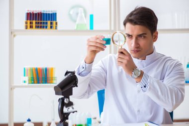Laboratuvarda kimyasallar üzerinde çalışan genç bir kimyager.