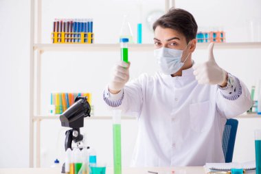 Laboratuvarda kimyasallar üzerinde çalışan genç bir kimyager.